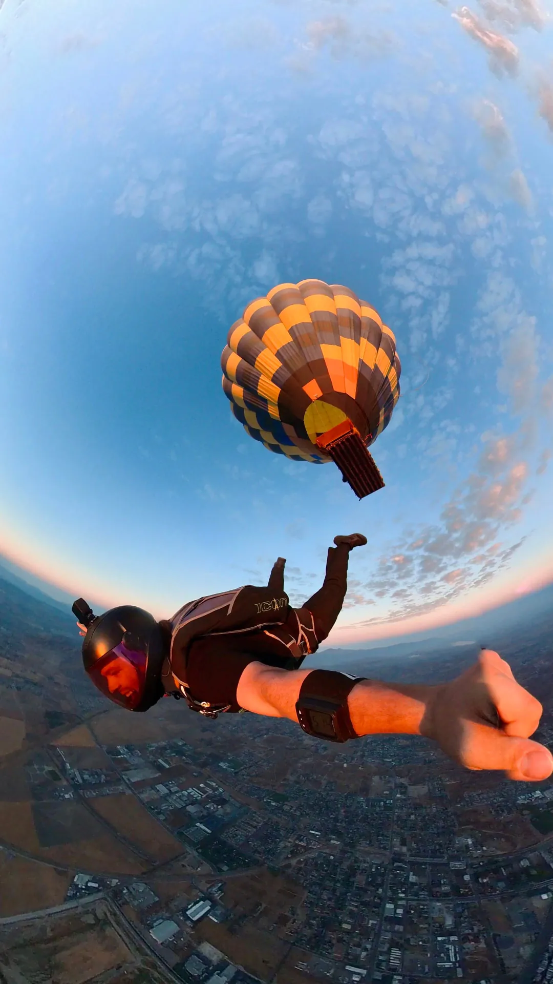 Skydiver in freefall just after exiting a hot air balloon at sunrise
